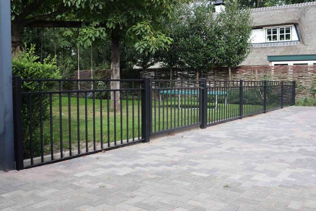 Impressie van een strak design hekwerk als omheining van een tuin bij een vrijstaand huis.