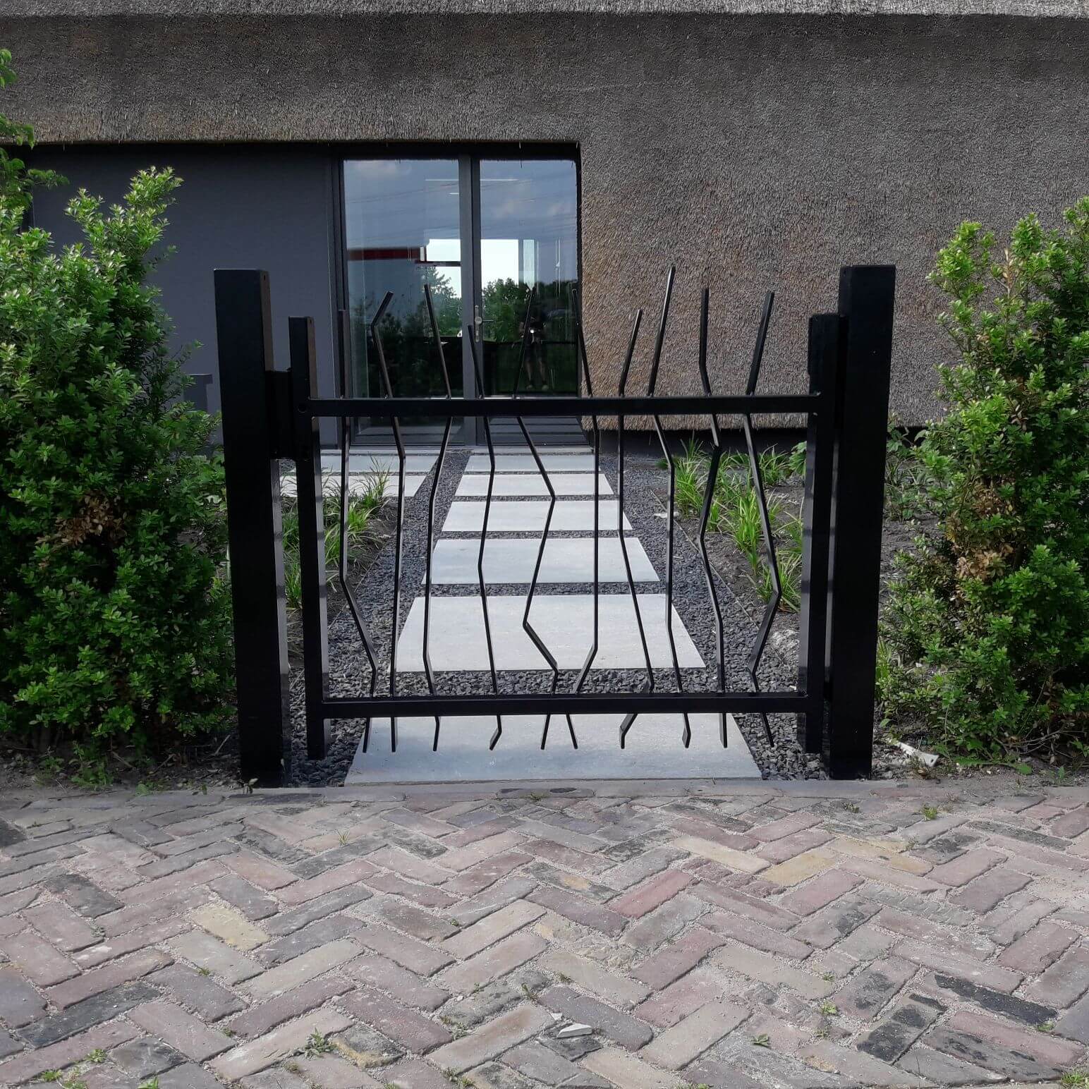 Impressie van een design looppoort, leidend naar de voortuin van een villa.