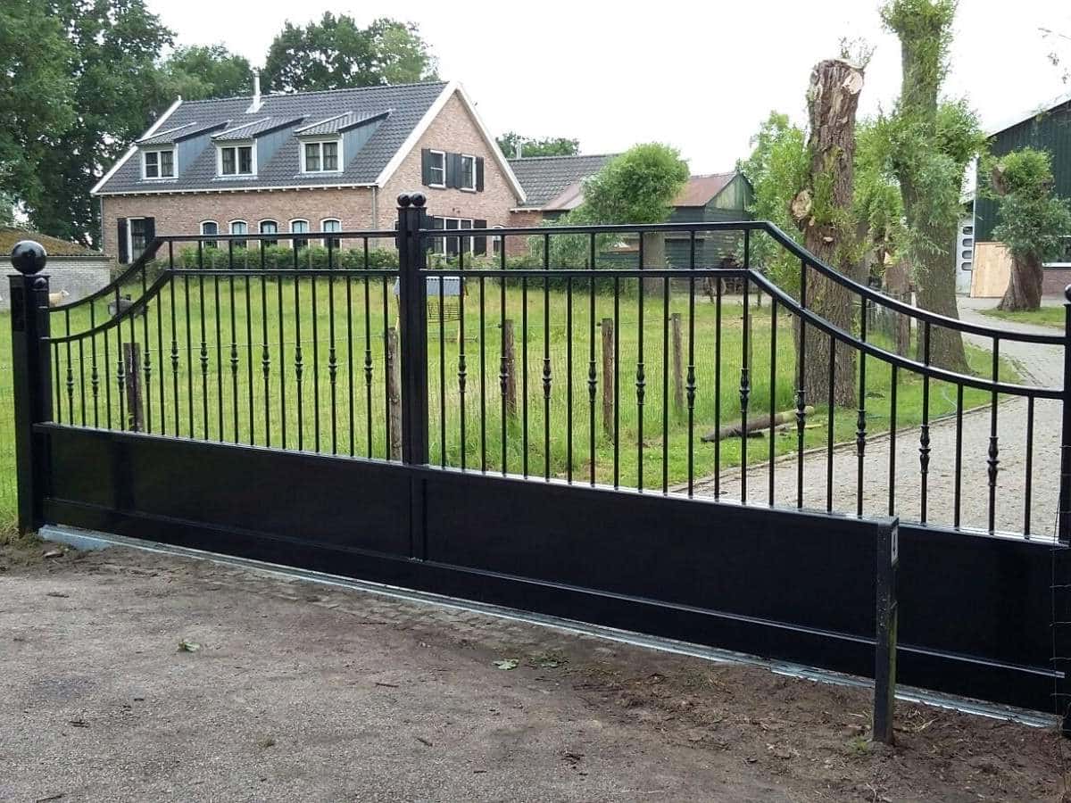 Impressie van een stalen schuifpoort in klassieke stijl, als entree naar een riant landgoed.